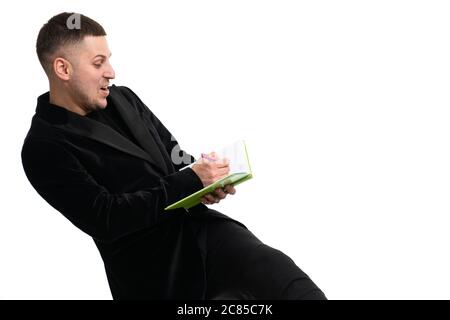 Jeune homme d'affaires heureux de prendre des notes dans un ordinateur portable Banque D'Images