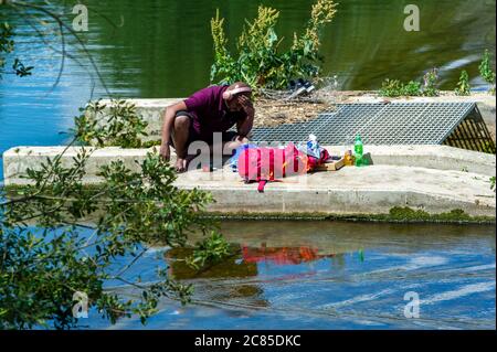 Slough, Berkshire, Royaume-Uni. 21 juillet 2020. Un homme est assis au sommet d'un déversoir au milieu de la rivière Jubilé. On a averti les gens de ne pas se rendre près du déversoir car il y a un risque de mort. Crédit : Maureen McLean/Alay Banque D'Images