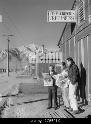 Roy Takeno (rédacteur) et des journaux de lecture de groupe devant le bureau, Yuichi Hirata, Nabuo Samamura, Manzanar Relocation Center, Californie, Etats-Unis, Ansel Adams, Manzanar War Relocation Center photographies, 1943 Banque D'Images