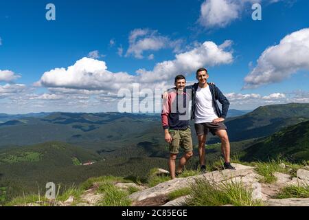 Deux hommes randonnée sur le Top of Mountain. Les randonneurs heureux gagnant atteindre le but de la vie, le succès, la liberté et le bonheur, la réalisation en montagne. Style de vie Banque D'Images