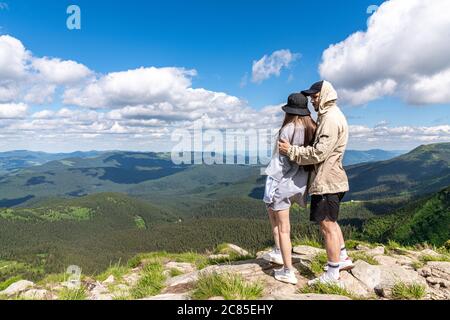 Vue arrière de randonneurs couple debout sur le dessus de la montagne et appréciant la vue pendant la journée Banque D'Images