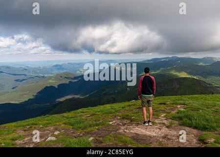 Voyageur debout sur la falaise de haute montagne, en admirant le paysage au sommet de la montagne. Vue POV. Concept de liberté de randonnée Banque D'Images