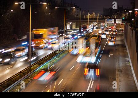 La circulation rapide passe le long d'une autoroute allemande qui mène du centre-ville de Munich à l'aéroport pendant la nuit de pointe. Banque D'Images