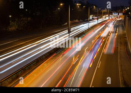 La circulation rapide passe le long d'une autoroute allemande qui mène du centre-ville de Munich à l'aéroport pendant la nuit de pointe. Banque D'Images