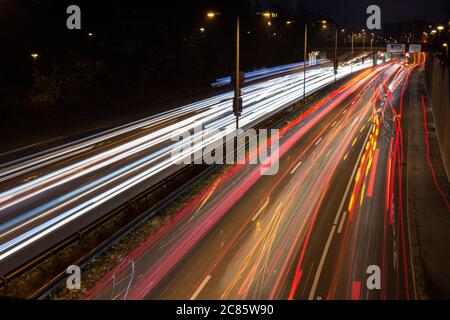 La circulation rapide passe le long d'une autoroute allemande qui mène du centre-ville de Munich à l'aéroport pendant la nuit de pointe. Banque D'Images