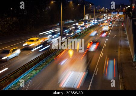 La circulation rapide passe le long d'une autoroute allemande qui mène du centre-ville de Munich à l'aéroport pendant la nuit de pointe. Banque D'Images