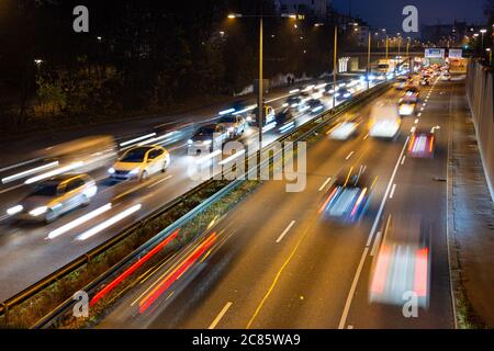 La circulation rapide passe le long d'une autoroute allemande qui mène du centre-ville de Munich à l'aéroport pendant la nuit de pointe. Banque D'Images