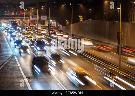 La circulation rapide passe le long d'une autoroute allemande qui mène du centre-ville de Munich à l'aéroport pendant la nuit de pointe. Banque D'Images