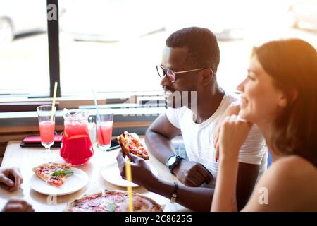 Affaires, alimentation, déjeuner et personnes concept - happy business team eating pizza in office Banque D'Images