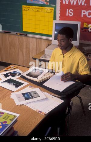 Austin Texas USA, 2003 : un étudiant afro-américain de premier cycle prépare un rapport scolaire dans une salle de classe de son école. ©Bob Daemmrich Banque D'Images