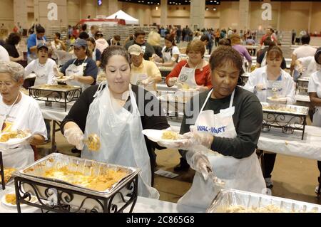 San Antonio, Texas États-Unis, 24 novembre 2005 : des volontaires adultes portant des gants en plastique et des tabliers mettent de la nourriture dans des assiettes lors du dîner annuel de Thanksgiving Raul Jiminez, où plus de 25 000 repas sont servis le jour de Thanksgiving pour les personnes âgées, les sans-abri, les pauvres et les déplacés du sud du Texas. L'événement, créé par le défunt restaurateur Raul Jiminez, en est à sa 26e année. ©Bob Daemmrich Banque D'Images