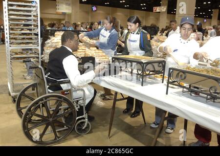 San Antonio, Texas États-Unis, 24 novembre 2005 : un homme afro-américain en fauteuil roulant sert au dîner annuel de Thanksgiving Raul Jiminez où plus de 25 000 repas le jour de Thanksgiving sont servis pour les personnes âgées, les sans-abri, les pauvres et les déplacés du sud du Texas. L'événement, créé par le défunt restaurateur Raul Jiminez, en est à sa 26e année. ©Bob Daemmrich Banque D'Images