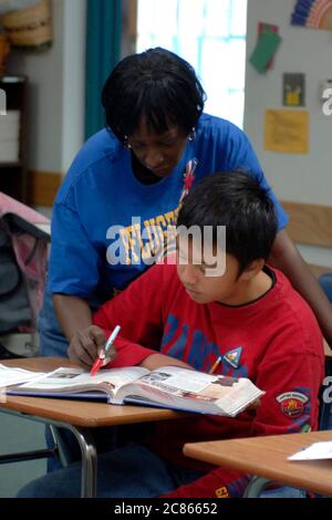 Pflugerville, Texas, États-Unis, novembre 2005 : un enseignant noir interagit avec un élève de sixième année de la classe cultures du monde dans le district scolaire de banlieue à l'extérieur d'Austin. ©Bob Daemmrich Banque D'Images