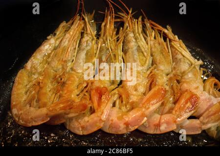 Crevettes crevettes dans l'huile sur une casserole en fonte Banque D'Images