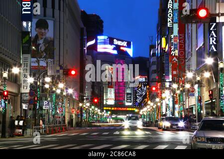 Rue par nuit dans le quartier Shibuya, Tokyo. Une rue pleine de lumières la nuit. Certaines personnes sont visibles sur les trottoirs. Banque D'Images