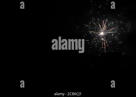 explosion d'un feu de cheminée à fusée chrysanthème unique avec des traces de fumée et de lumière sur un fond noir solide avec espace de copie Banque D'Images