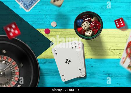 Bahamas thème casino. Jeu de poker, cartes et jetons sur table rouge avec fond de drapeau national. Jeux et Paris. Banque D'Images