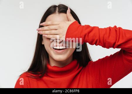 Portrait d'une jeune femme brunette très gaie portant des vêtements décontractés isolés sur fond blanc, couvre les yeux Banque D'Images