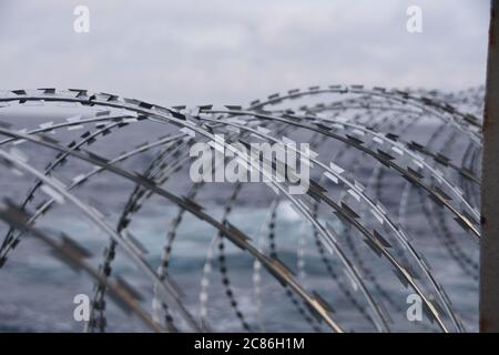 Détail du fil barbelé attaché à la coque, à la superstructure et aux rails du navire pour protéger l'équipage contre les attaques de piraterie dans le golfe de Guinée. Banque D'Images