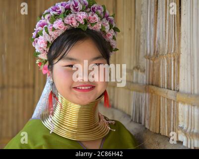 Chubby Thai/birman long-cou Kayan salesgirl (« girafe women ») avec tribal Padaung bagues de cou / bobines en laiton sourit pour la caméra. Banque D'Images