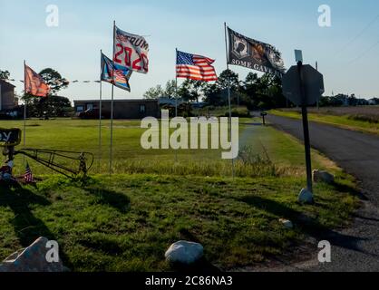 Drapeaux volant sur une petite parcelle de terre dans un village sur la côte est du Maryland. Banque D'Images