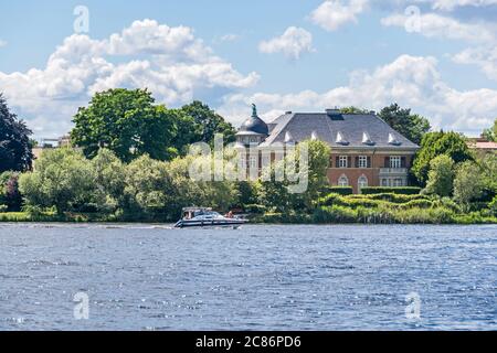 Potsdam, Allemagne - 12 juillet 2020 : Lac Glienicker avec le bâtiment classé de la Villa Kampffmeyer et une famille sur le bateau de loisirs Banque D'Images