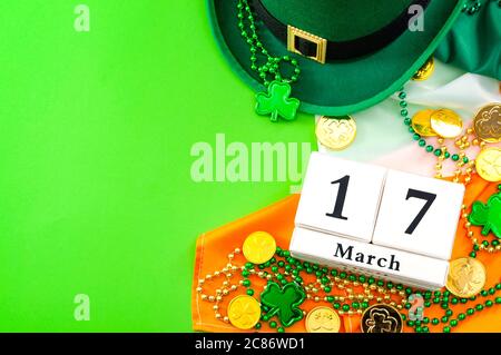 La chance de l'Irish meme et le thème Happy St Patrick Day avec un calendrier, un chapeau de lepretchun, un collier de perles et des pièces d'or sur le drapeau de l'Irlande Banque D'Images