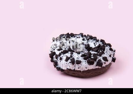 faire un donut dans un glaçage au chocolat noir avec des morceaux de chocolat Banque D'Images