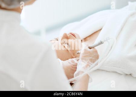 Femme caucasienne obtenant la procédure de peeling du visage dans une clinique de beauté, gros plan. Soin liquide au gaz du visage rajeunissant. Opération de nettoyage de la peau Hydro air Banque D'Images