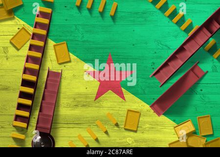 Drapeau de la Guyane française sur fond national avec dominos sur table en bois. Vue de dessus. Concept de jeu. Banque D'Images