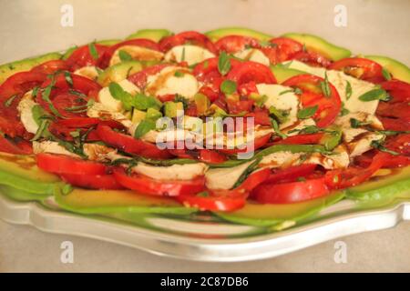 Plat alimentaire avec tomate, mozzarella et avocat. Plats végétariens et végétaliens. Mise au point sélective au centre avec flou volontaire. Banque D'Images