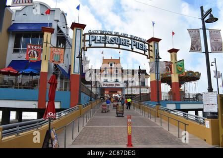 Les visiteurs et le personnel se rendent sur la bretelle d'entrée de l'embarcadère de plaisance historique de Galveston Island dans le golfe du Mexique. Le restaurant Bubba Gump est vu. Banque D'Images