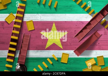 Drapeau du Suriname sur fond national avec dominos sur table en bois. Vue de dessus. Concept de jeu. Banque D'Images