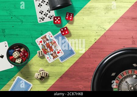 République du Congo casino thème. Jeu de poker Aces, cartes et jetons sur table rouge avec drapeau national en bois. Jeux et Paris. Banque D'Images