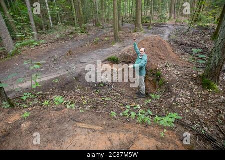 17 juillet 2020, Bavière, Nuremberg: Hans-Joachim Ulrich, forestier de la forêt bavaroise, envisage un saut à ski dans le Reichswald de Nuremberg construit par les motards eux-mêmes, qui doit être enlevé. Au milieu de la forêt, il y a de hauts sauts de ski dans de nombreux endroits - auto-construit avec des planches et des troncs d'arbre et pas toujours sans danger. En raison des dommages causés à la forêt et à la nature, mais aussi en raison du danger d'accidents, certains sauts à ski seront démolis. (À dpa 'l'ardeur de la construction dans la forêt: Des ennuis avec les pistes illégales de VTT') photo: Daniel Karman Banque D'Images