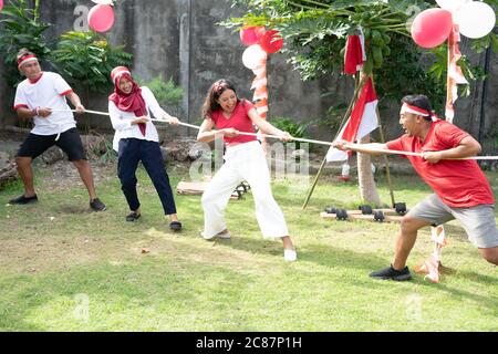 Un groupe de jeunes a participé à un groupe de concours de guerre lors des célébrations de la journée de l'indépendance en Indonésie sur le terrain avec des ballons et de petits drapeaux rouges et blancs Banque D'Images