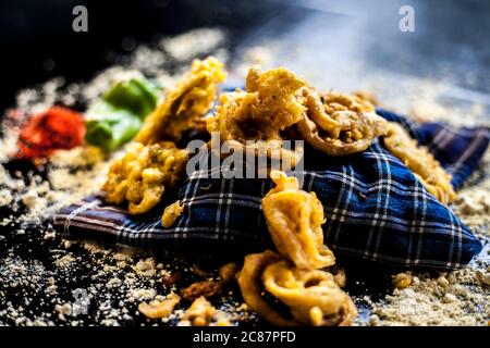 Célèbre kanda bhaji ou kanda bhajiya ou kanda pakora dans un récipient sur une surface noire avec la farine de pois chiches, les épices, et tous les autres ingrédients pour Banque D'Images