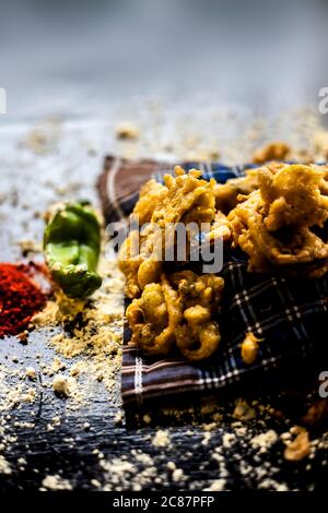 Célèbre kanda bhaji ou kanda bhajiya ou kanda pakora dans un récipient sur une surface noire avec la farine de pois chiches, les épices, et tous les autres ingrédients pour Banque D'Images
