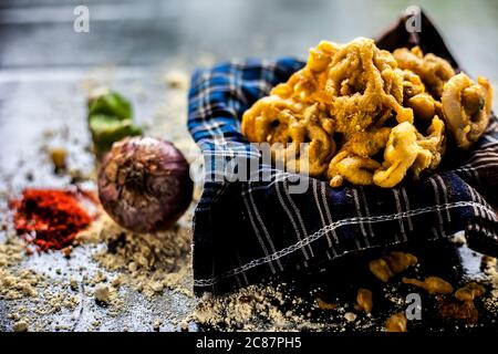 Célèbre Kanda bhaji ou Kanda bhajiya ou Kanda pakora dans un récipient sur une surface noire avec de la farine de pois chiches, des épices, des oignons, et tous les autres ingrédients Banque D'Images