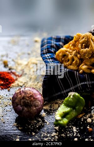 Célèbre Kanda bhaji ou Kanda bhajiya ou Kanda pakora dans un récipient sur une surface noire avec de la farine de pois chiches, des épices, des oignons, et tous les autres ingrédients Banque D'Images