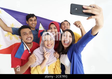 un supporter philippin prenant le portrait de selfie ensemble tenant le drapeau des philippines pendant le jour de l'indépendance Banque D'Images