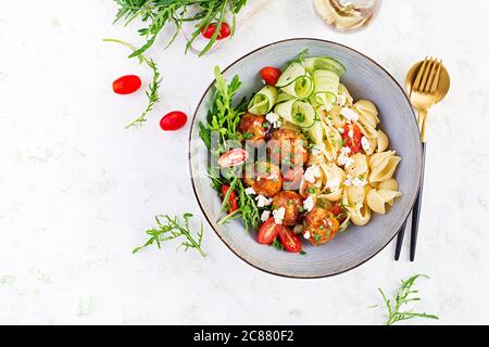 Pâtes italiennes. Conchiglie avec boulettes de viande, fromage feta et salade sur fond clair. Dîner. Vue de dessus, au-dessus de la tête. Concept de Slow Food Banque D'Images