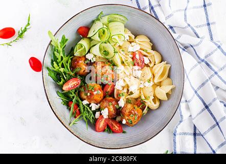 Pâtes italiennes. Conchiglie avec boulettes de viande, fromage feta et salade sur fond clair. Dîner. Vue de dessus, au-dessus de la tête. Concept de Slow Food Banque D'Images