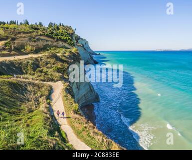 Vue depuis le point de vue de Peroulades sur une pente de roche blanche Falaise de la baie volcanique de Cape Drastis et Peroulades avec mer tropicale turquoise clair Banque D'Images