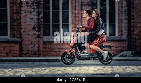 20-07-2020 Riga, Lettonie charmant jeune couple conduisant du vélo électrique pendant l'été. Ville moderne datant et transport. Banque D'Images