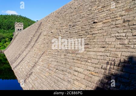 Le long du mur en pierre courbe du barrage Derwent, dans le Derbyshire, jusqu'à la tour nord du barrage. Banque D'Images