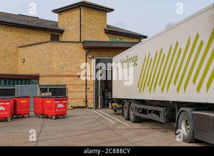 Remorque HGV récemment garée, appartenant à une chaîne de supermarchés britannique bien connue, déchargeant des produits frais vers le magasin de marchandises à l'arrière du supermarché. Banque D'Images