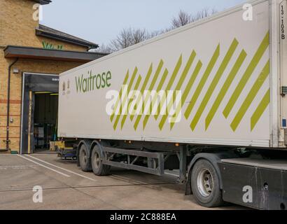 Remorque HGV récemment garée, appartenant à une chaîne de supermarchés britannique bien connue, déchargeant des produits frais vers le magasin de marchandises à l'arrière du supermarché. Banque D'Images