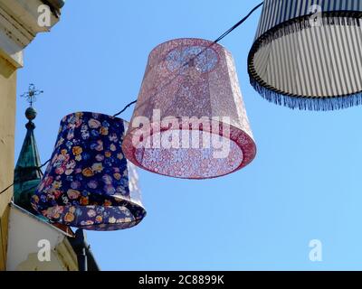 Lumières extérieures en toile colorées, lanternes ou lampes au-dessus de la rue publique dans une ville pittoresque d'Europe. ambiance de fête et de vacances d'été Banque D'Images