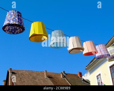 Lumières extérieures en toile colorées, lanternes ou lampes au-dessus de la rue publique dans une ville pittoresque d'Europe. ambiance de fête et de vacances d'été Banque D'Images